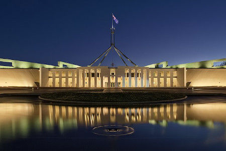 A large Australian flag sits atop Parliament House in Canberra, Australia