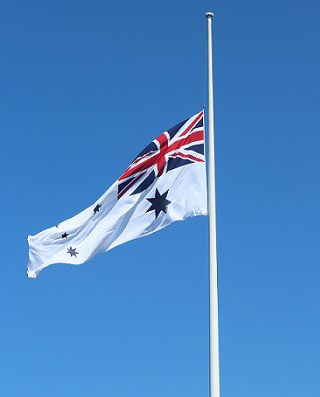 The Australian Naval Ensign flying at half mast